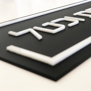 שלט לדלת ברקע שחור עם אותיות בולטות בלבן - ShapeMixer